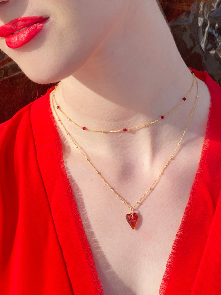 Layering of ruby red heart necklace ansd satellite gold necklace by Desideri design