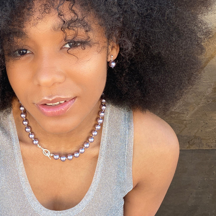 Lavender colored pearls jewelry on a model 